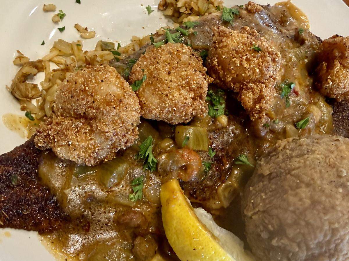 The “Kitchen Sink” platter featueres blackened redfish topped with étouffée, fried shrimp and a boudin ball at Cocodrie’s in North Richland Hills, Texas, Oct. 5, 2025.