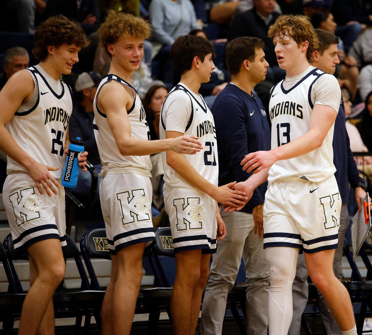 Keller point guard Brooks Bahr (13) low-fives team mates as he returns to the bench for a rest in the third period of a high school basketball game in the Keller High School gym in Keller Texas, Friday, Feb. 02, 2024.