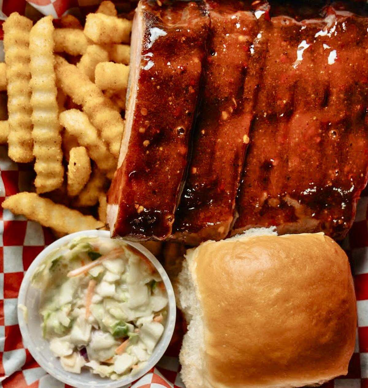 A baby back rib dinner with hot honey sauce, fries and slaw at Ribbee’s in Fort Worth.