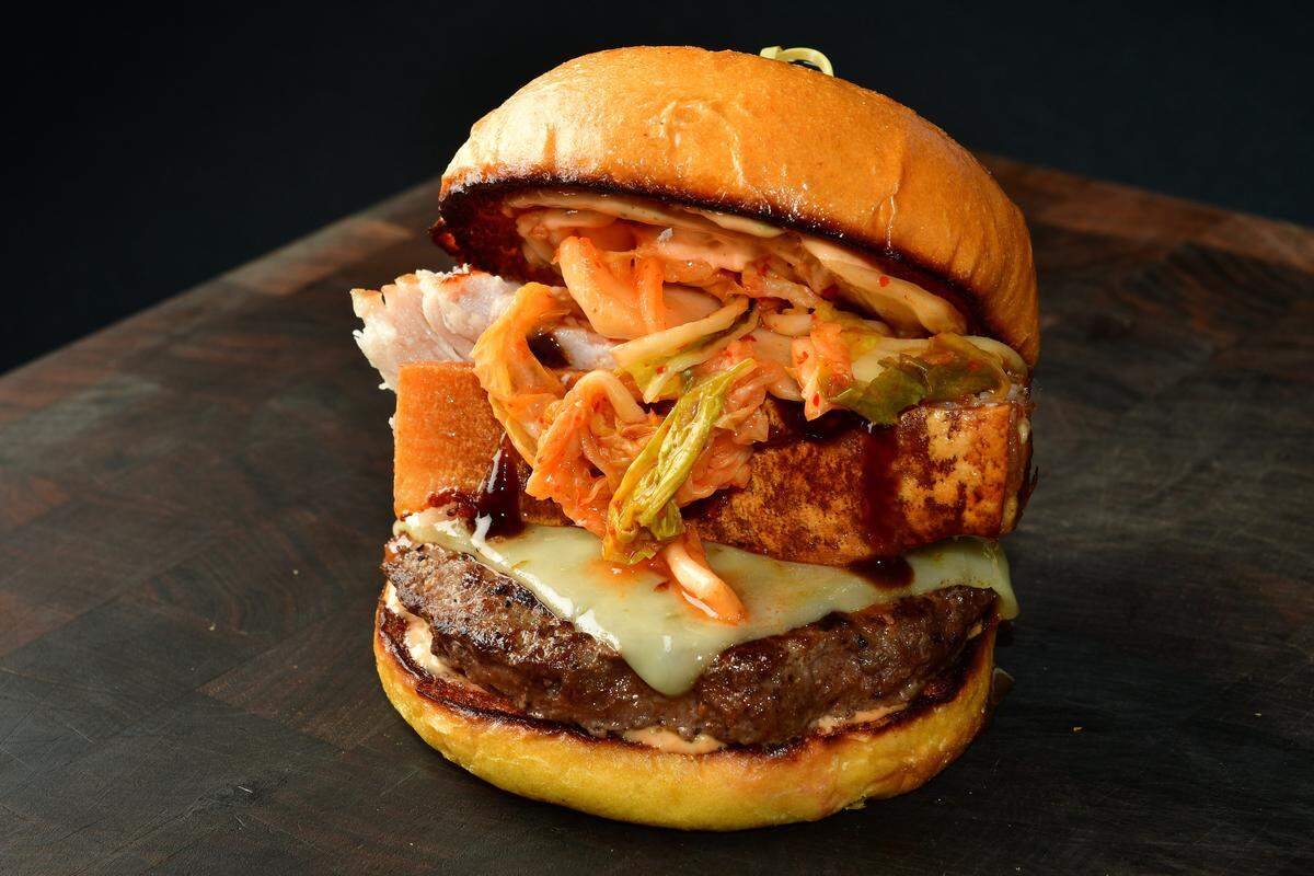Pork belly burger at AT&T Stadium: Crispy pork belly piled on to an Angus burger, topped with jalapeño cheese, fresh kimchi, aioli and hoisin sauce. Eat it before it eats you.