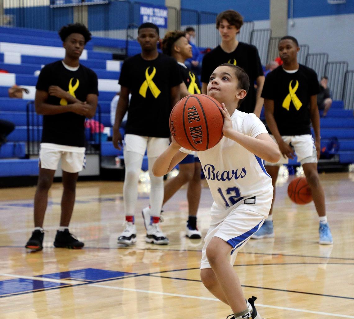 Team mates look on as Carter Escobar,9, shoots a few free throws during warmups before a high school basketball game at Brewer High School in White Settlement, Texas, Friday, Feb. 14, 2020. Escobar suffers from a childhood cancer and also Long QT Syndrome which is a disorder of the hearts electrical activity. Playing basketball for the Brewer Bears was on his bucket list. (Special to the Star-Telegram Bob Booth)