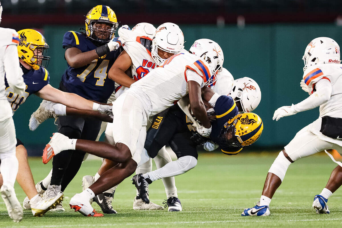 Arlington Lamar running back Caden Hall (21) is tackled by a swarm of Arlington Bowie defenders in a district match up against at Choctaw Stadium in Arlington, Texas on October 30, 2025.