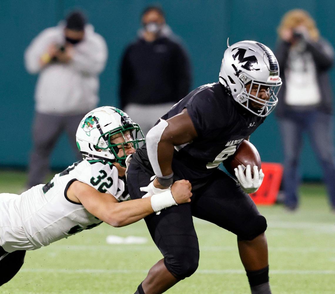 Martin running back DK Smittick (9) drags Southlake Carroll’s Benecio Porras (32) for a few yards during a Conference 6A Division 1 regional playoff football game at Globe Life Park in Arlington, Texas, Friday, Dec. 24, 2020. Southlake Carroll led Arlington Martin 17-11 at the half. (Special to the Star-Telegram Bob Booth)