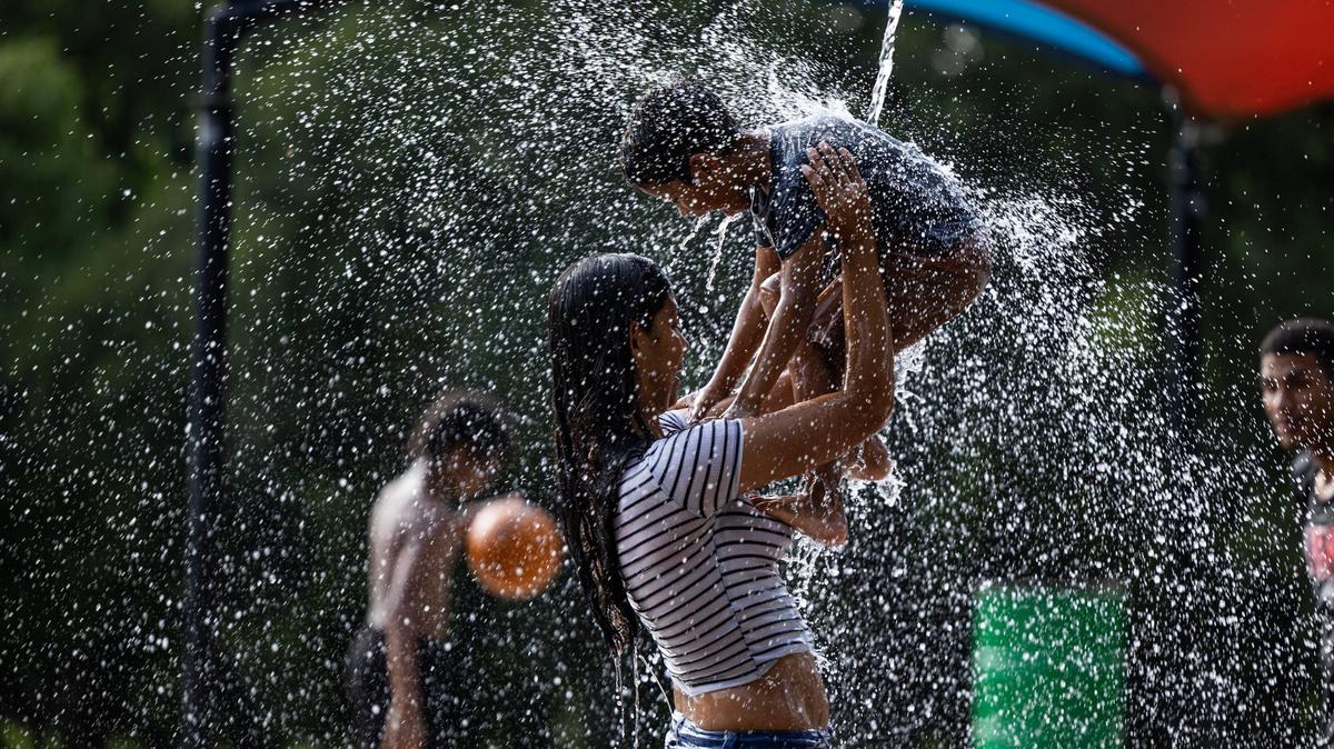 Saraes Reyes holds her son Jose Serrano-Reyes, 5, under the water on the splash pad at Sycamore Water Park in Fort Worth on Thursday, June 27, 2024. Temperatures rose to over 100 degrees as the summer heatwave begins to heat up.