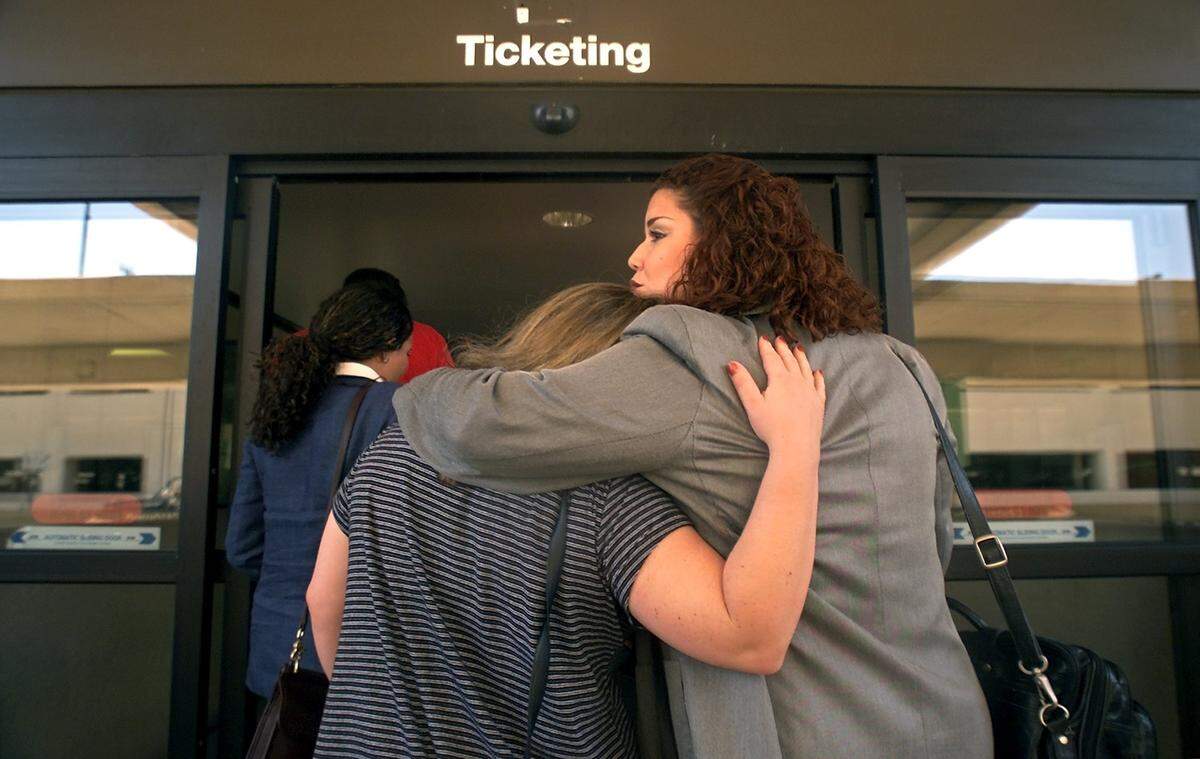 American Eagle employees Heather Carter, left, and Mary Vazquez comfort each other while returning to their workplace at the Dallas-Fort Worth International Airport the day after the Sept. 11, 2001, terrorist attacks. Every terminal was ordered searched by the FAA.
