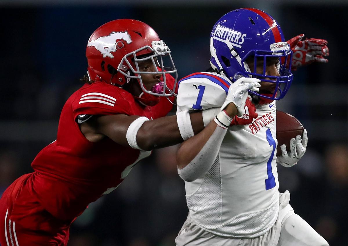Duncanville running back Trysten Smith (1) is pulled down by North Shore defensive back Upton Stout (L) during the first half of the 5A Division II High School State Football Championship game played at AT&T Stadium in Arlington, TX, Saturday, December 21, 2019.