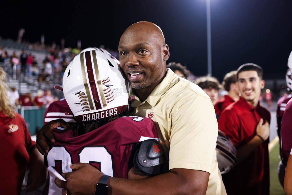 Keller Central head coach Eric Vance hugs one of his players as the final seconds on the clock expire during a district game between Keller Central and L.D. Bell at Keller ISD Stadium in Keller, Texas on October 16, 2025.