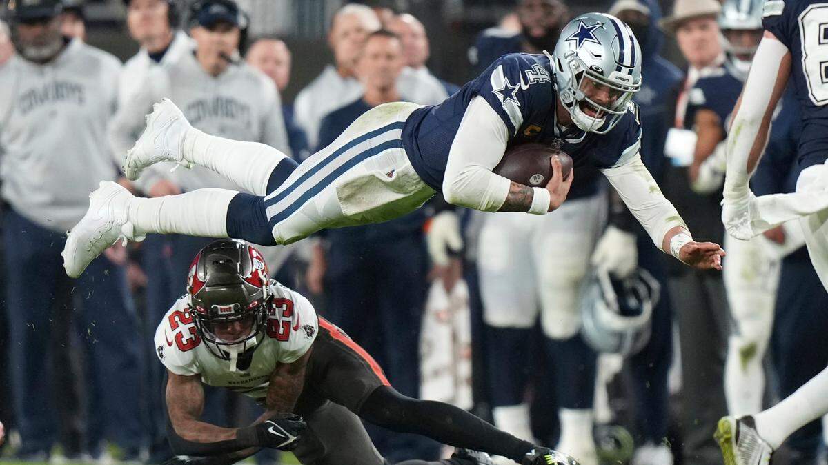 Dallas Cowboys quarterback Dak Prescott (4) dives over Tampa Bay Buccaneers cornerback Sean Murphy-Bunting (23) for a first down during a wild card NFL football playoff game, Monday, in Tampa, Fla.