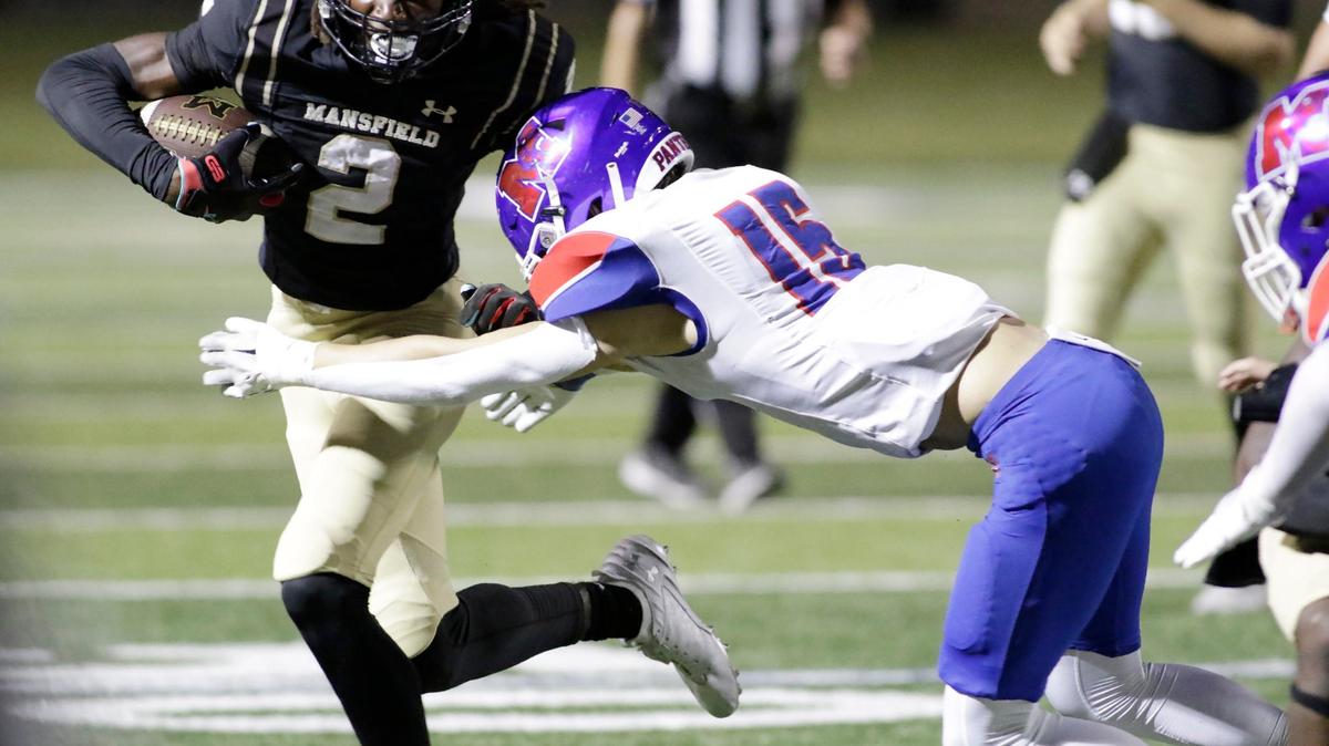 Mansfield’s Zion Robinson tries to escape a tackle by Waco Midway’s Lincoln Fischer during a UIL football game at Vernon Newsome Stadium in Mansfield on Thursday, Sept. 19, 2024.