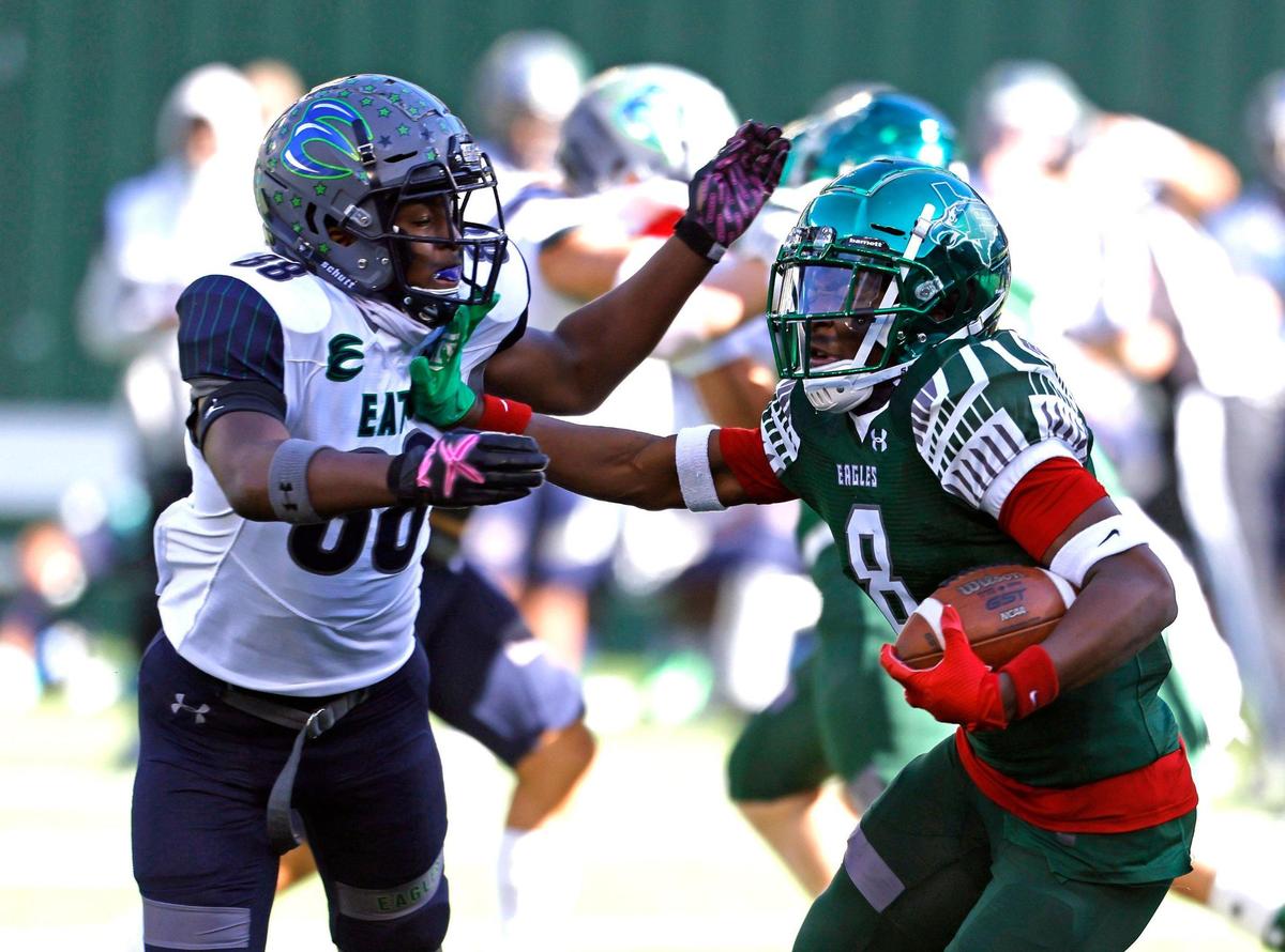 Prosper wide receiver Tyler Bailey (8) stiff arms Eaton defender Charles Whitebear (88) during a Conference 6A Division 2 regional playoff football game at Globe Life Park in Arlington, Texas, Saturday, Dec. 26, 2020. Prosper led 13-3 at the half. (Special to the Star-Telegram Bob Booth)