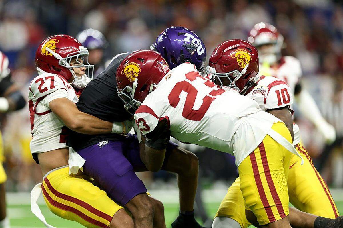 SAN ANTONIO, TEXAS - DECEMBER 30: Eric McAlister #1 of the TCU Horned Frogs is tackled by Desman Stephens II #23 and Alex Graham #27 of the USC Trojans during the second quarter of the game at Alamodome on December 30, 2025 in San Antonio, Texas. (Photo by Kenneth Richmond/Getty Images)
