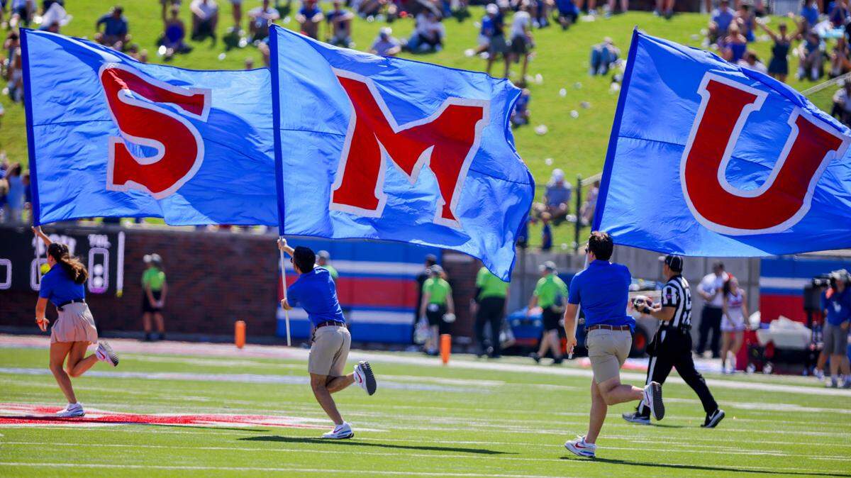 SMU flags are run across the field during a time out in the second half of an NCAA college game against TCU on Saturday, Sept. 24, 2022, in Dallas.