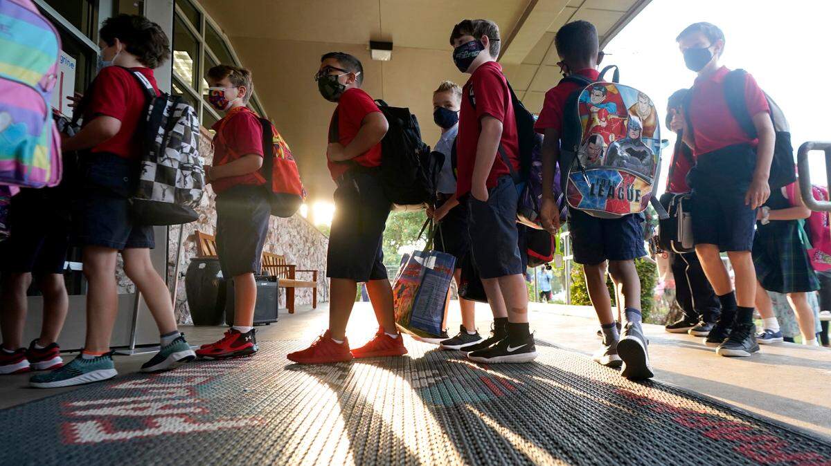 Wearing masks to prevent the spread of COVID-19, elementary school student line up to enter school for the first day of classes in Richardson. Despite Texas Gov Greg Abbott’s executive order banning mask mandates by local officials, the Richardson school district and many others across the state are requiring masks for students.
