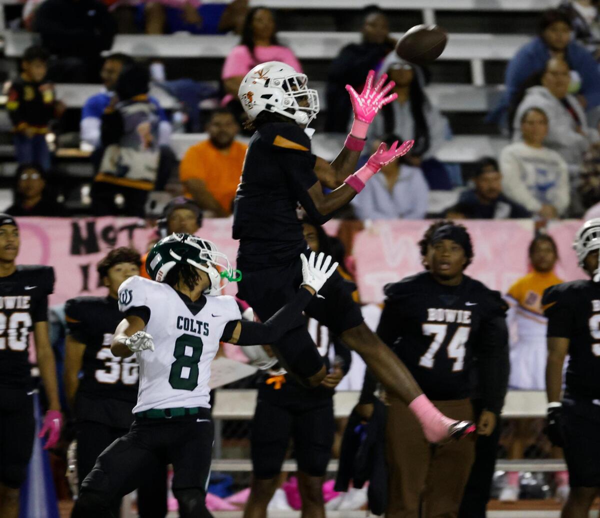 Bowie wide receiver Dilon Tallie (8) goes high for a catch in front of Arlington defensive back Deon Mays (8) during a District 8-6A football game at C.H. Wilemon Field in Arlington, Texas, Friday, Oct. 18, 2024.