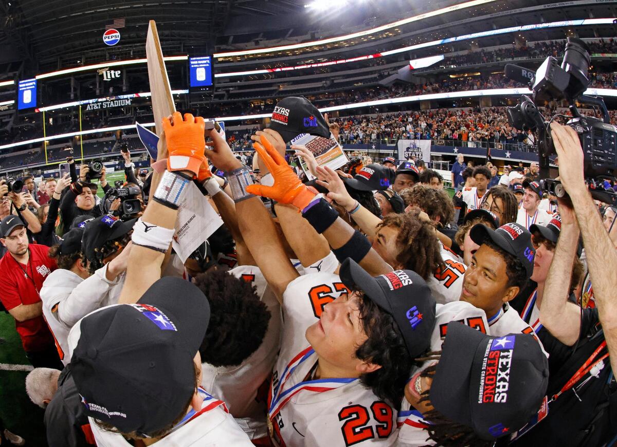 The GIlmer Buckeyes reach for the championship plaque after winning the UIL Conference 4A Division 2 state championship football game at AT&T Stadium in Arlington, Texas, Friday, Dec. 15, 2023.