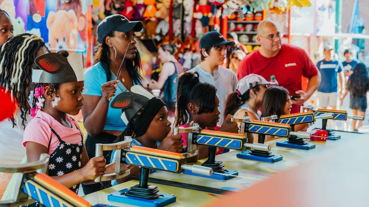 Families playing carnival games at Main Street Fest in 2024.