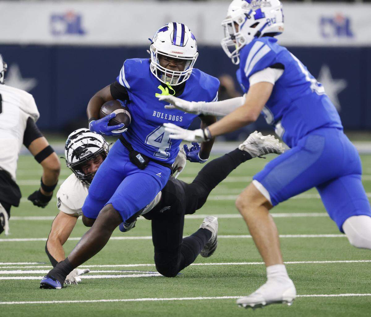Yoakum running back Germarquis Robinson (4) is tripped up by Grandview middle linebacker Bleu Hubbard (5) during the first half of a UIL Class 3A Division I championship game on Thursday Dec. 18, 2025 at AT&T Stadium in Arlington, Texas.