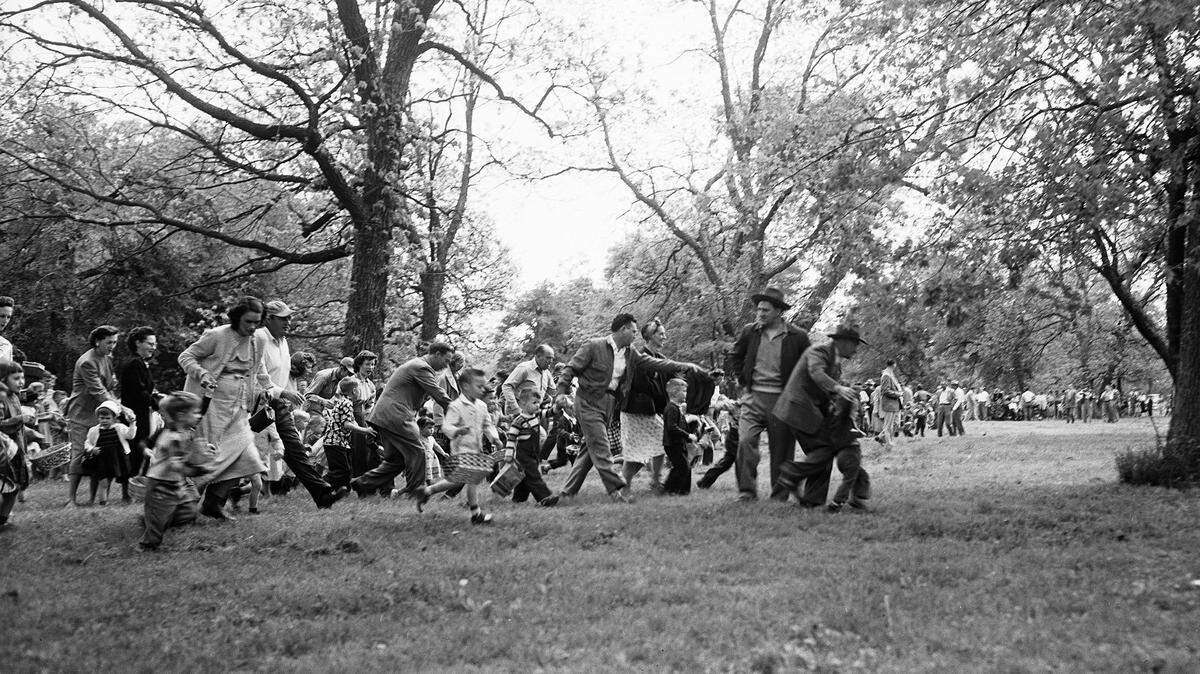Children, many shepherded by their parents, raced to find Easter eggs hidden by local Jaycees in Trinity Park. This photograph was taken in 1953, during the heart of the post-war baby boom.