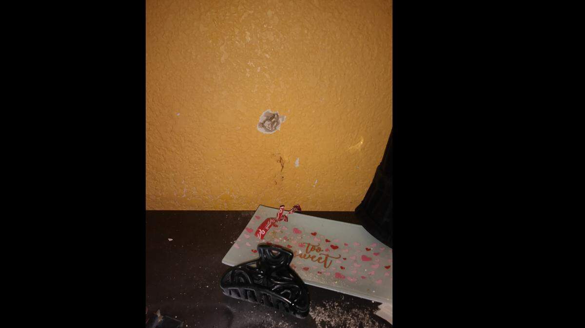 A bullet ripped through the wall of a room at the Knights Inn on Friday night, narrowly missing a 23-year-old woman who was lying on the bed below.