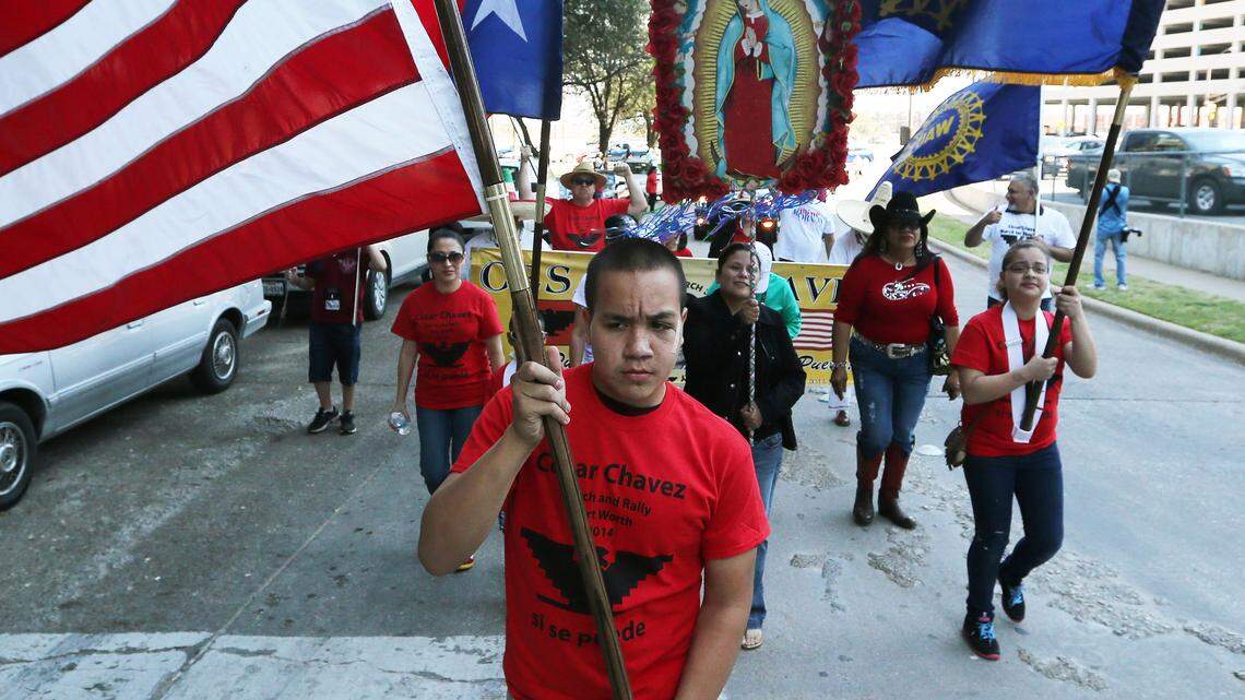 In this photo from 2014, Nino Avila carries the US flag ahead of about 1,000 participants marching through downtown Fort Worth to honor the birthday of American labor leader and civil rights activist Cesar Chavez.