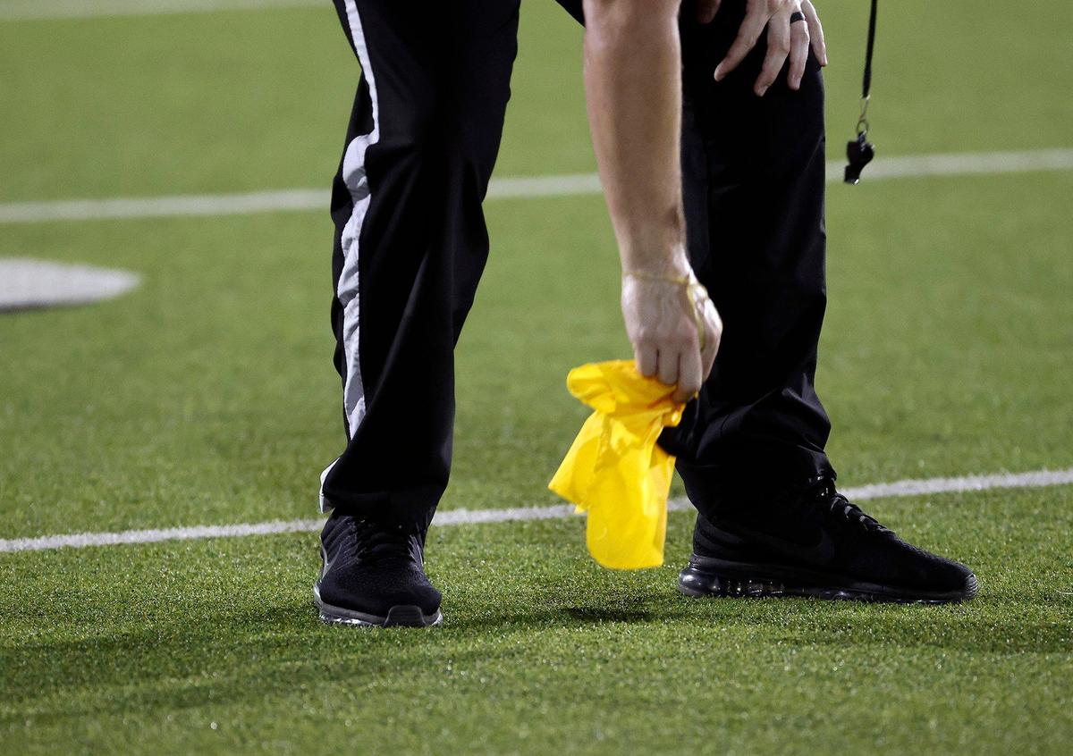 An official picks up a penalty flag in the second half of an UIL football game at Keller ISD Stadium in Keller, Texas, Thursday Aug. 31, 2023.