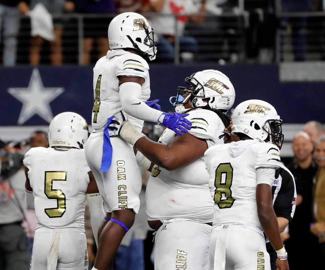 South Oak Cliff offensive lineman Brione Ramsey-Brooks (58) lifts running back Qualon Farrar (4) after Farrar’s touchdown run during a high school 5A division 2 state championship football game at AT&T Stadium in Arlington, Texas, Saturday, Dec. 18, 2021. SOC defeated Liberty Hill 23-14 to bring Dallas its first championship since 1958. (Special to the Star-Telegram Bob Booth)