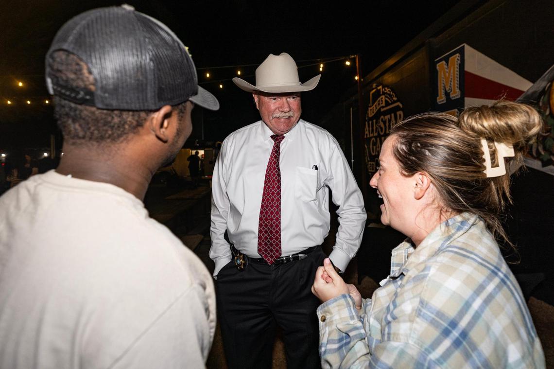 Tarrant County Sheriff Bill Waybourn speaks to attendees Matthew Stampp, left, and Alyssa Smith at his election party at Hurtado Barbecue in Arlington on Tuesday, Nov. 5, 2024.