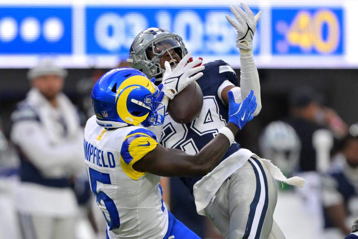 Aug 9, 2025; Inglewood, California, USA; Dallas Cowboys safety Israel Mukuamu (24) intercepts a pass intended for Los Angeles Rams wide receiver Konata Mumpfield (15) during the second half at SoFi Stadium. Mandatory Credit: Jayne Kamin-Oncea-Imagn Images