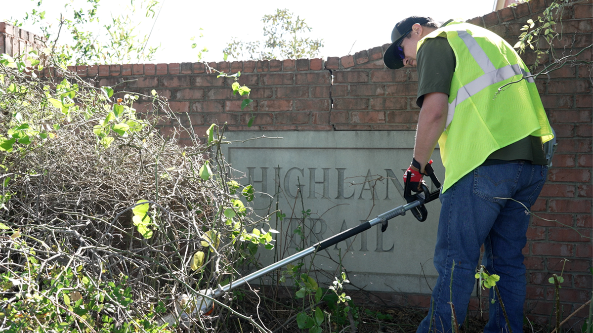 A member of the Arlington Clean Corridor Program, aka the Clean Team, cuts away weeds and shrubbery. The program, which started in March, is designed to make the city cleaner and safer for citizens.