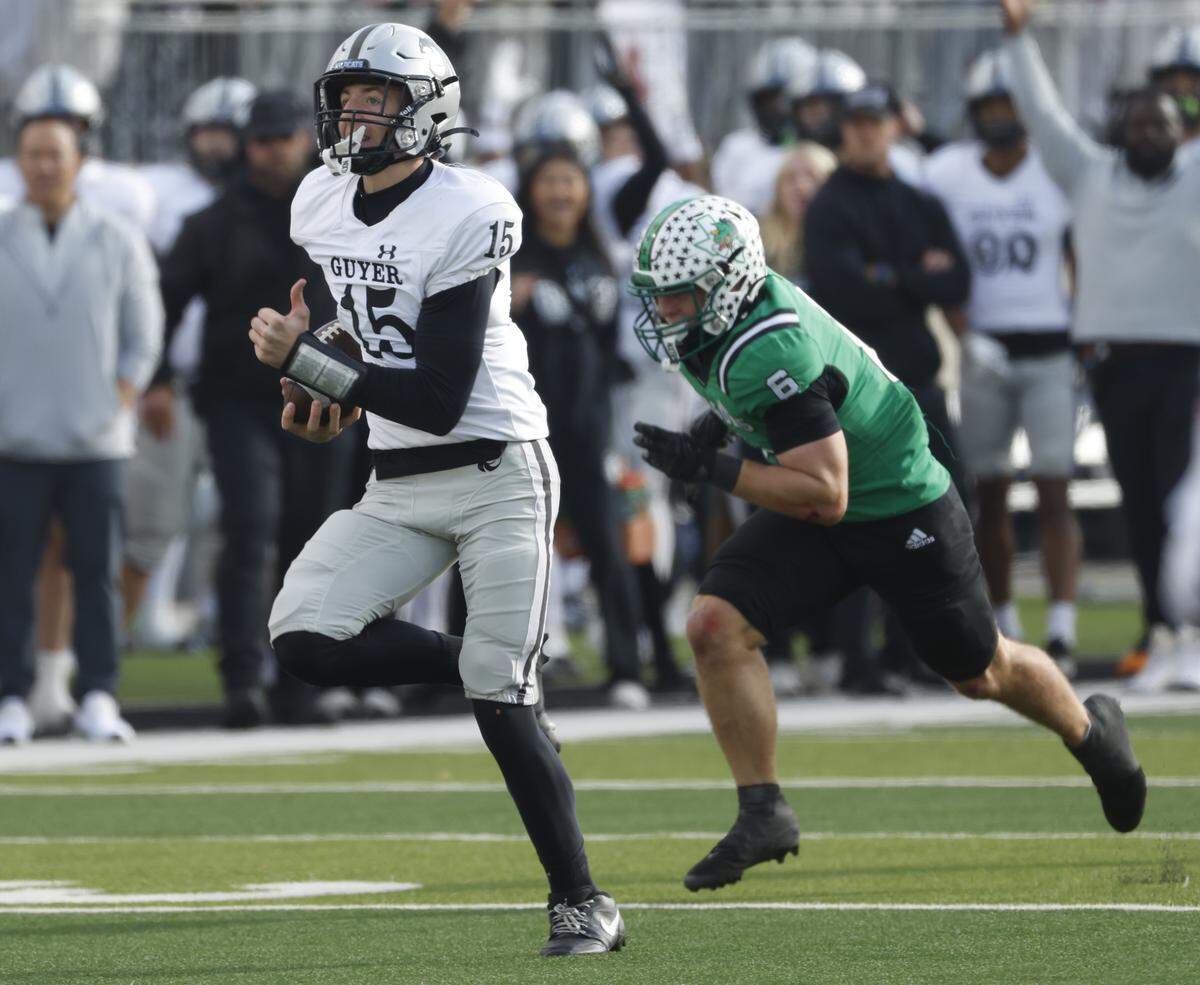 Denton Guyer quarterback Carter Morgan (15) outruns Southlake Carroll defensive back Parker Harris (6) during the first half of a UIL Class 6A Division II Quarterfinal on Saturday Dec. 06, 2025 at Crowley ISD Multi-Purpose Stadium in Fort Worth, Texas.