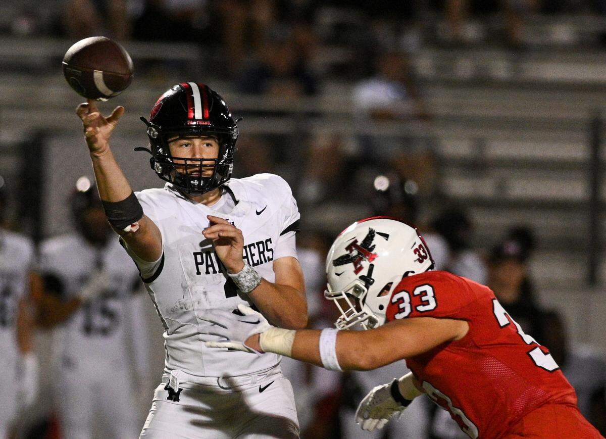 Colleyville Heritage quarterback Bodey Weaver (2) throws the ball as Argyle linebacker Brody Bomar (33) goes in for a tackle during a UIL football game at Eagle Stadium in Argyle, Texas on Friday, Sept. 27, 2024.