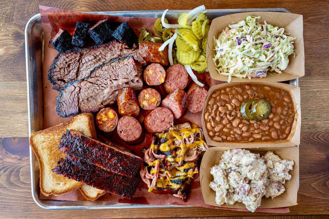 A Cousins BBQ combo platter with brisket, ribs, two kinds of sausage and pork with mustard sauce.