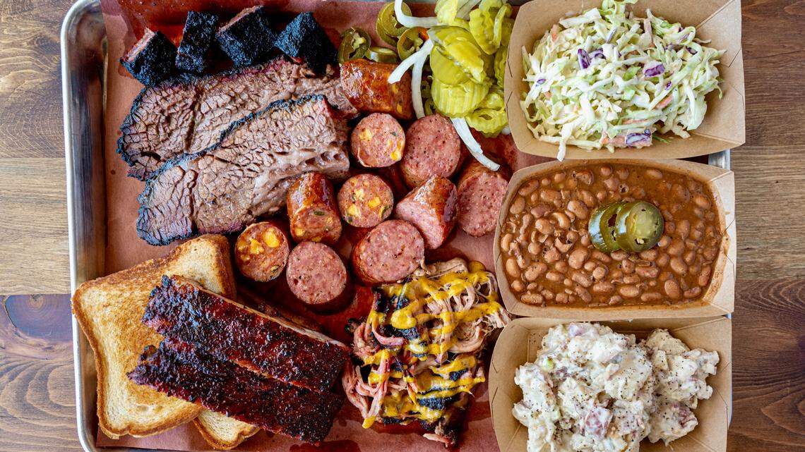 A Cousins BBQ combo platter with brisket, ribs, two kinds of sausage and pork with mustard sauce.