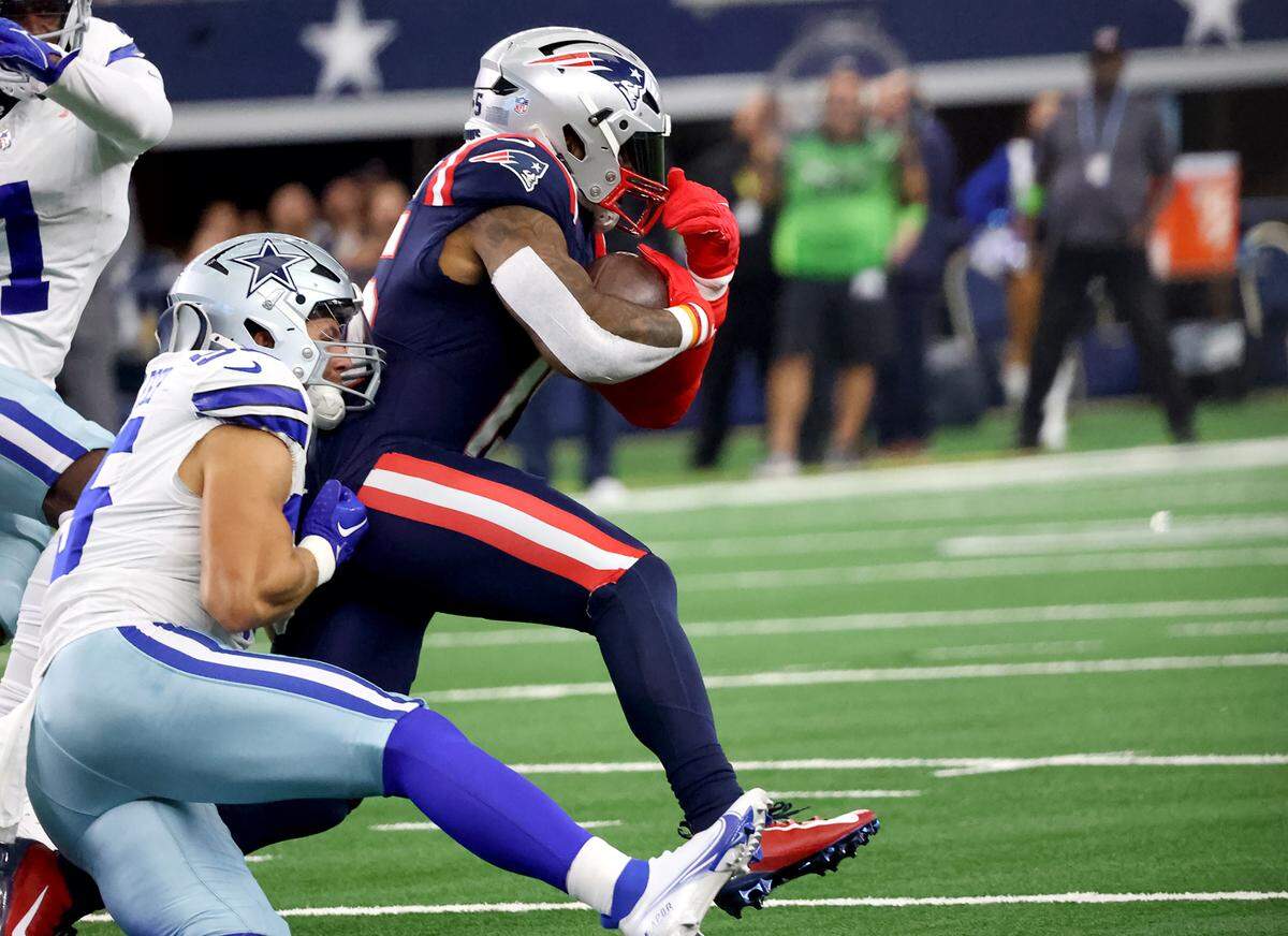 New England Patriots running back Ezekiel Elliott runs the ball in the first quarter while Dallas Cowboys linebacker Leighton Sander Esch slows his down on Sunday, October 1, 2023, at AT&T Stadium in Arlington.