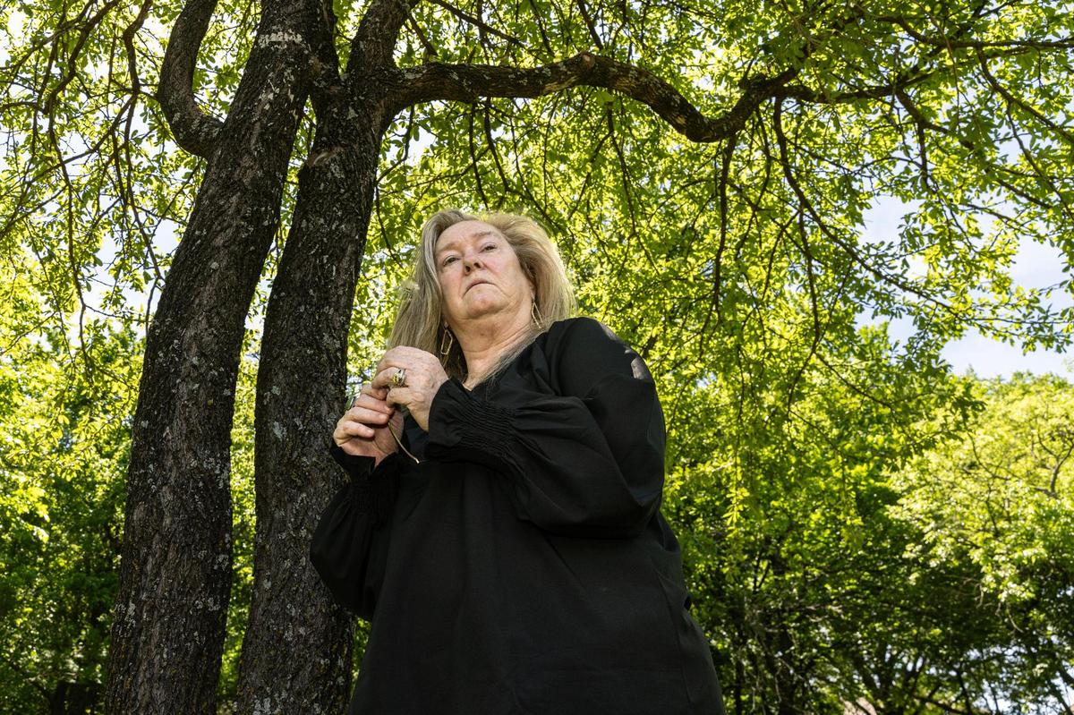 Tricia Hanson blows the seeds off a dandelion in memory of her daughter, Sara, at Quail Ridge Park in Fort Worth on April 11, 2024. Sara Hanson was shot to death in August 2020 by her boyfriend, Garrett Benson, in their hotel room in Bossier City, Louisiana. At the park, a memorial bench is dedicated to Sara’s life.