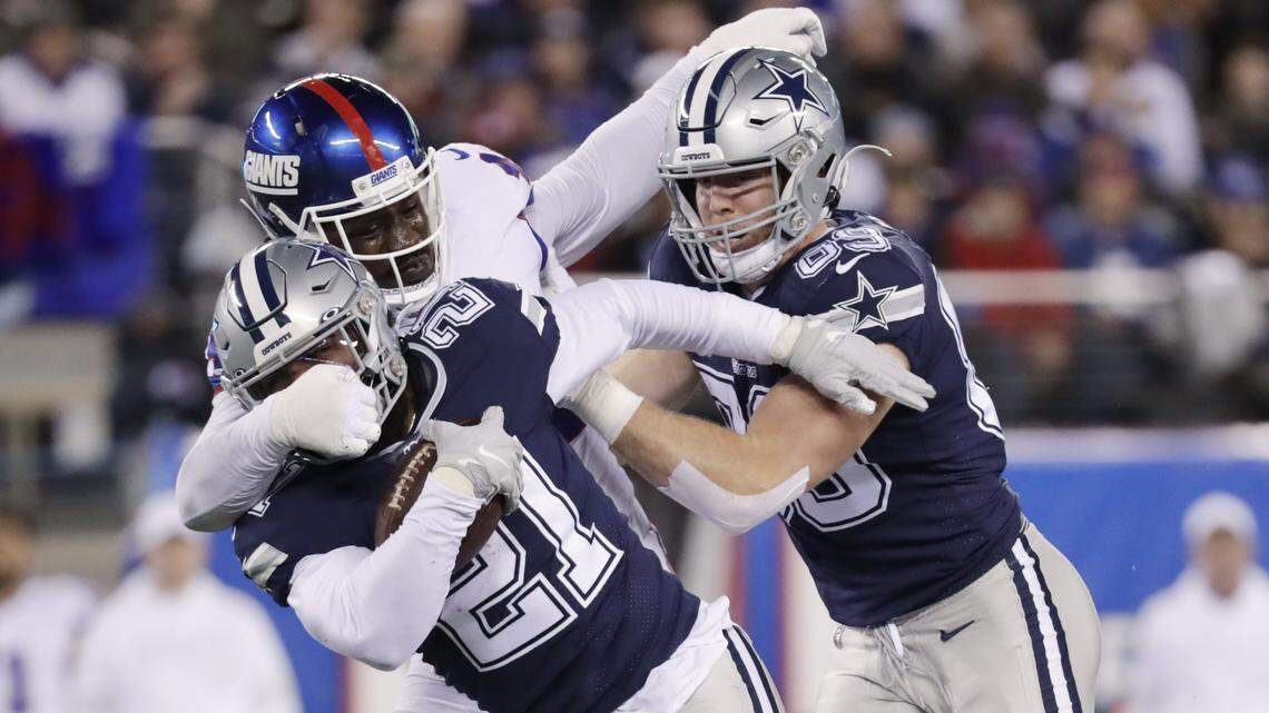 New York Giants linebacker Markus Golden (44) tackles Dallas Cowboys running back Ezekiel Elliott (21) during the first quarter Monday.