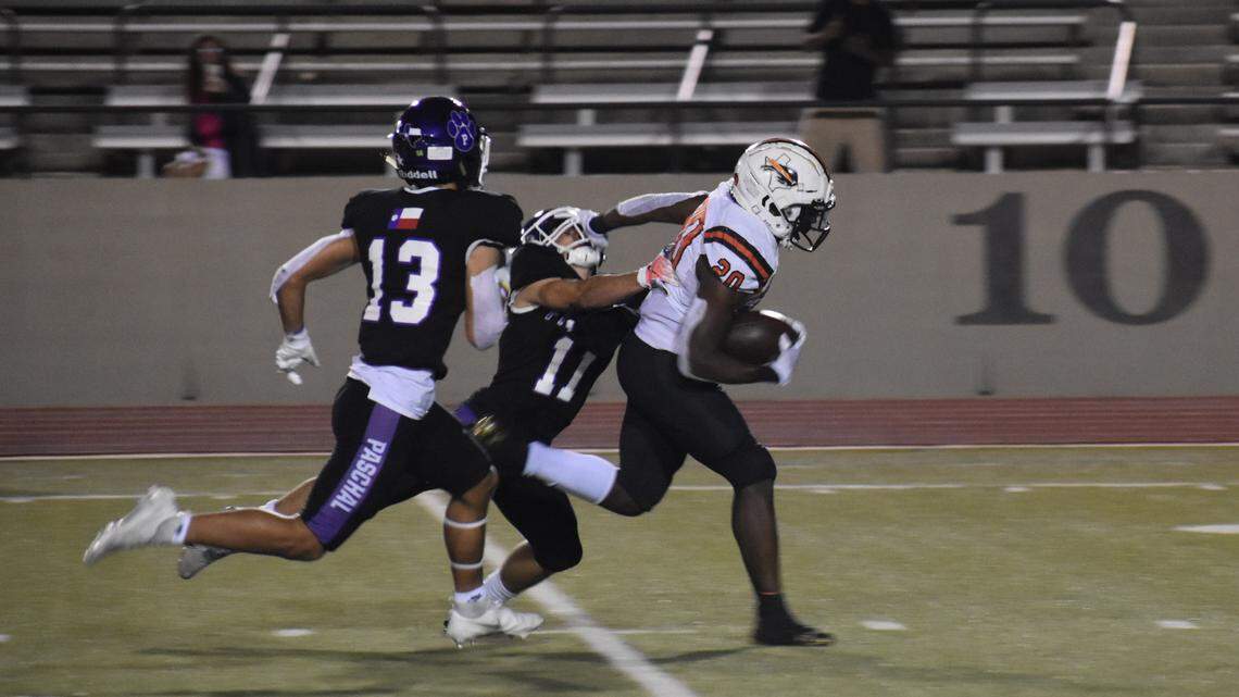 Haltom’s A.J. Reynolds (20) stiff arms Paschal’s Cash Peck (11) as he goes in for a touchdown during a football game at Farrington Field in Fort Worth, Texas, Friday, Oct. 15, 2021, Haltom won 51-20. (Michelle Escalante/Special to the Star-Telegram)