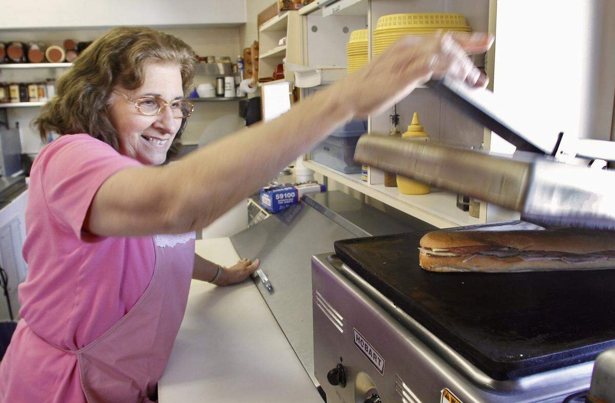 Umelia Neira uses a hot press to toast a Cuban sandwich at Cuco's Sandwich Shop in North Richland Hills on Dec. 6, 2010.