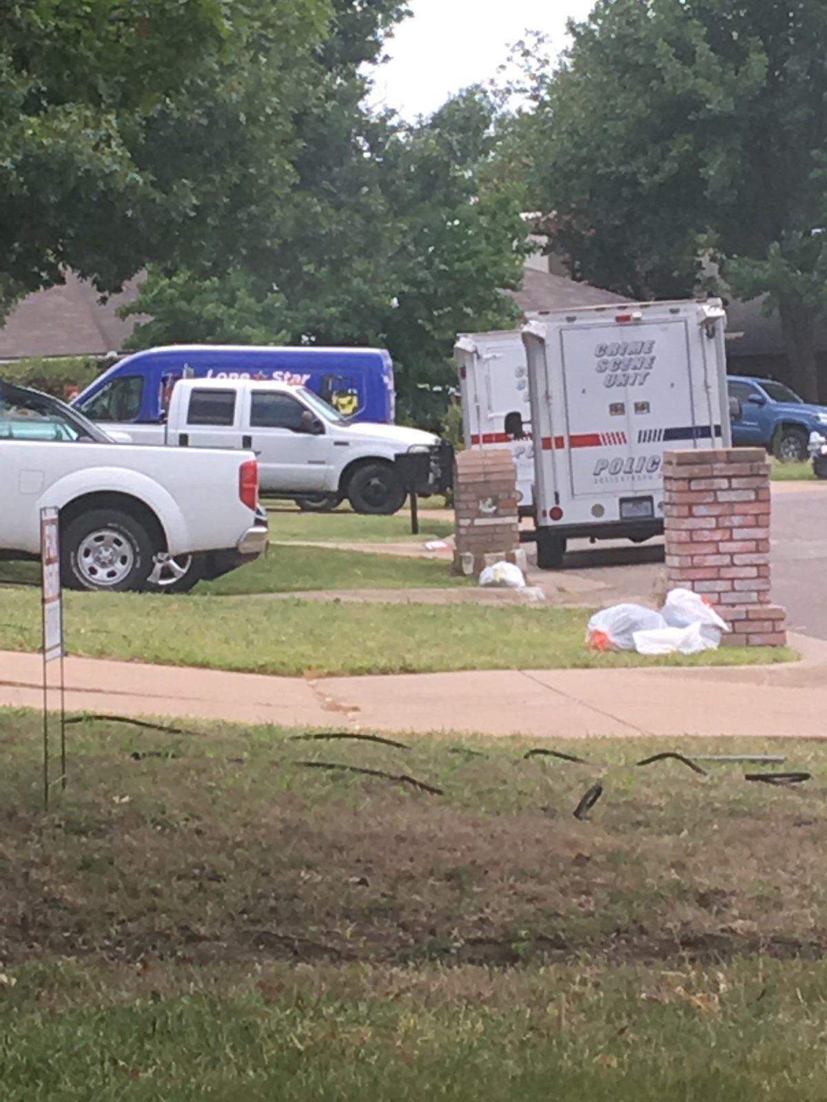 Police cars sit outside the Livermore Drive home in Arlington where officers discovered a dead woman and a dead man, killed in an apparent murder-suicide. The suspect had a history of domestic abuse, according to his ex-mother-in-law and court records.