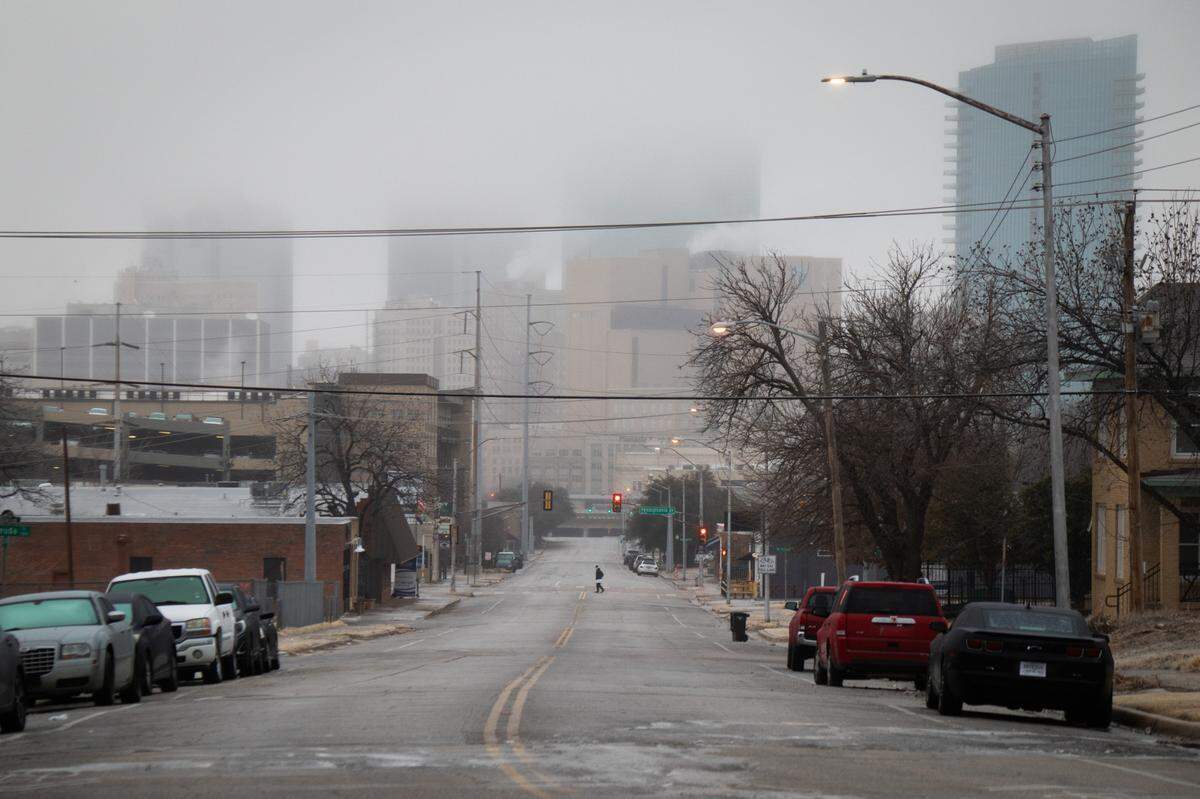A person slowly walks across an icy Jennings Avenue on Thursday, Feb. 24, 2022 in downtown Fort Worth.