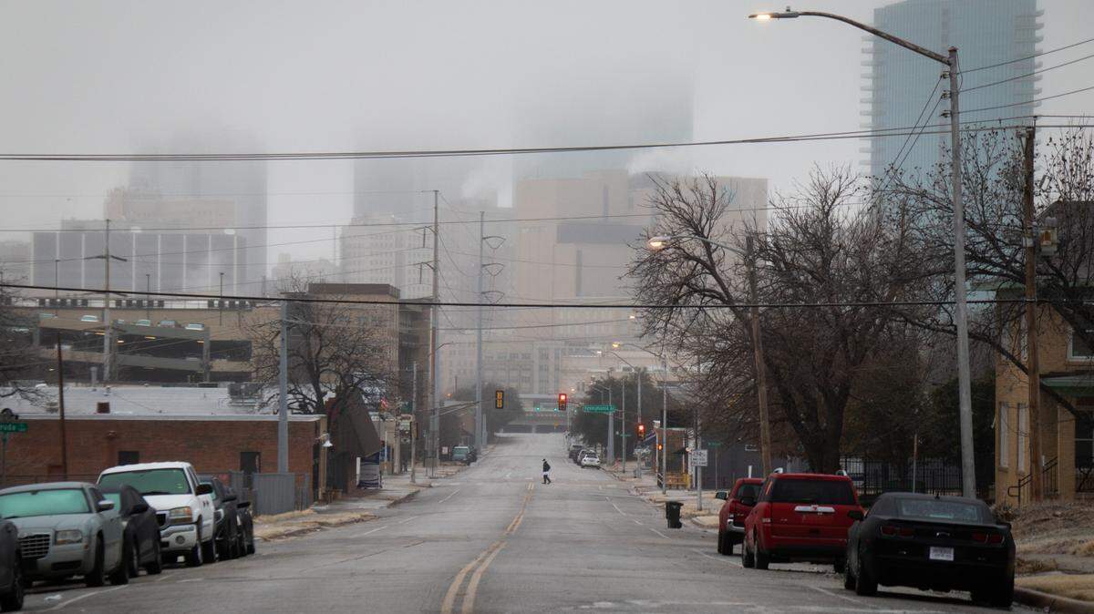 A person slowly walks across an icy Jennings Avenue on Thursday, Feb. 24, 2022 in downtown Fort Worth.