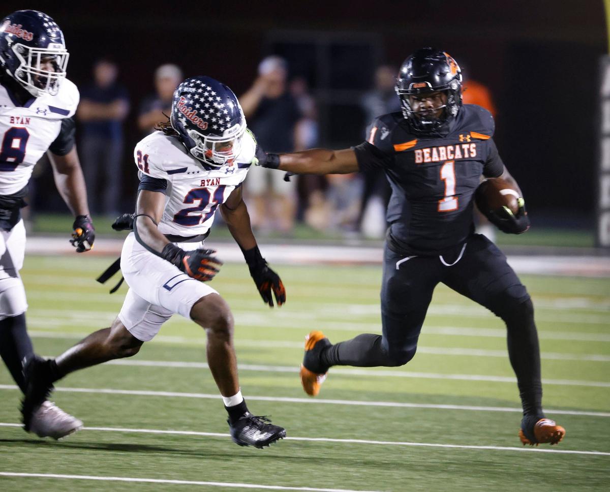 Aledo running back Racine Guillory (1) stiff arms Denton Ryan linebacker Dillon Arkansas (21) for yards during a UIL football game at Buchanan Stadium in Aledo Texas, Friday, Oct. 04, 2024.