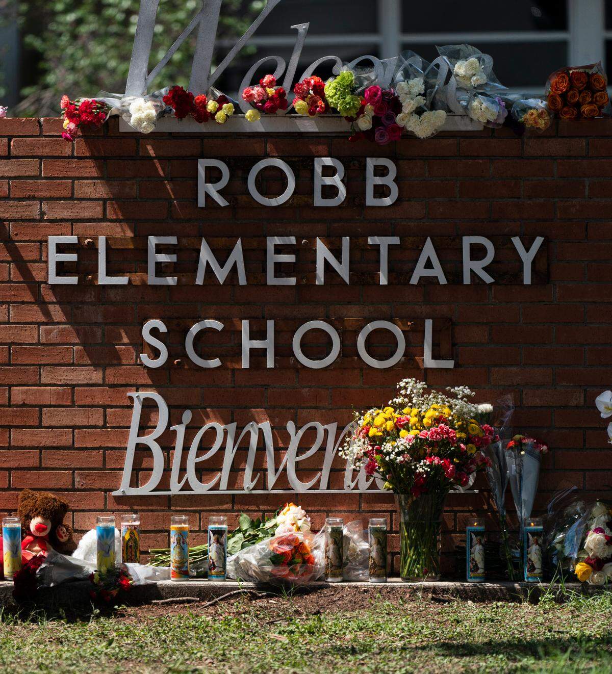 A law enforcement personnel lights a candle outside Robb Elementary School in Uvalde, Texas, Wednesday, May 25, 2022. Desperation turned to heart-wrenching sorrow for families of grade schoolers killed after an 18-year-old gunman barricaded himself in their Texas classroom and began shooting, killing several fourth-graders and their teachers. (AP Photo/Jae C. Hong)