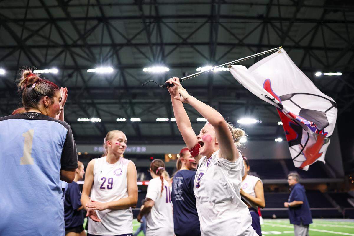 Grapevine defender Makena Kerr (19) waves a flag with the Mustang soccer logo in celebration after defeating Frisco Wakeland in a Class 5A Division II UIL girls soccer state semifinal at the Ford Center on April 3, 2026 in Frisco, Texas.