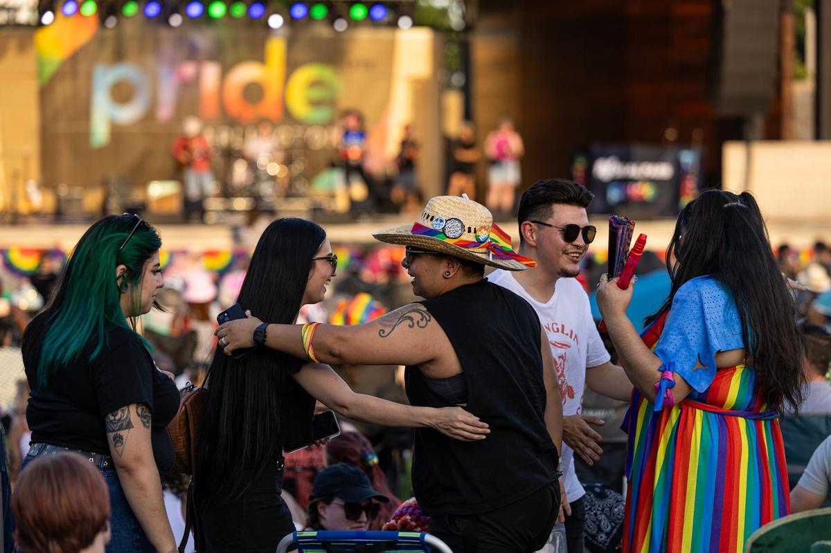 Abigail Reyes and Cassandra Marquez greet friends during a performance from Kameron Ross at the Arlington Pride event at Levitt Pavilion in Arlington on Saturday, June 8, 2024.