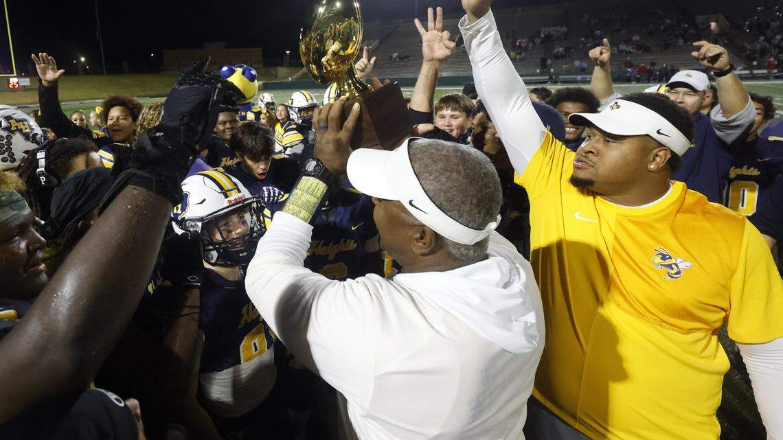 Fort Worth Arlington Heights head coach Curtis James holds up the trophy after the Class 5A Division I area-round playoff win against Lubbock Monterey on Nov. 20 at Shotwell Stadium in Abilene.