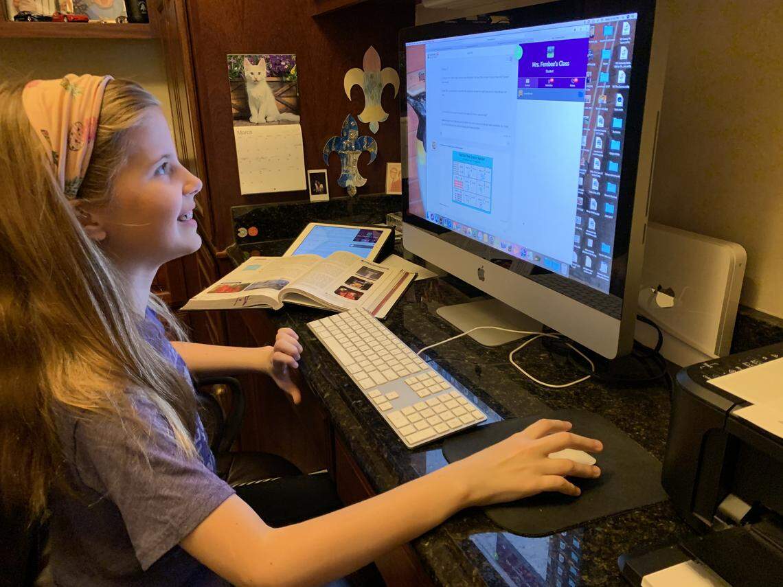 Lexie Brown, 11, checks her Seesaw app for comments from her teachers. She said she likes being able to go to school without being at school.