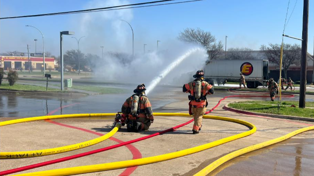 Firefighters work to douse a blaze in the front of a tractor trailer near S.W. Green Oaks Boulevard and Matlock Road in south Arlington Friday morning.