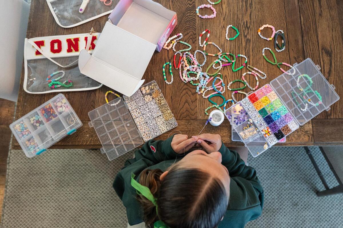 Max Grieshaber, 11, of Fort Worth makes bracelets in her home on Tuesday, July 15. The Grieshaber family is selling bracelets to raise money for victims of the flooding near Kerrville, Texas.