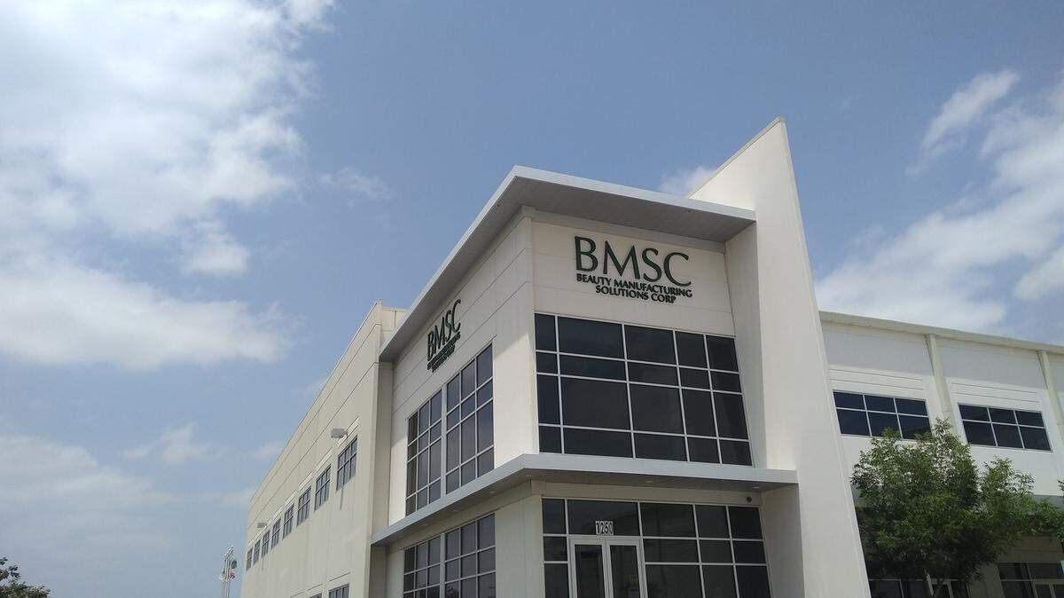 BMSC's Coppell facility is a two-story building with gray paint and large black windows. 